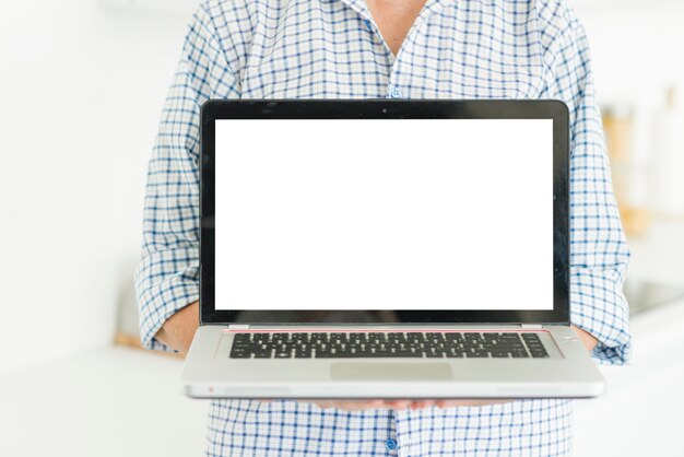 Torso de mujer mostrando portátil con pantalla en blanco