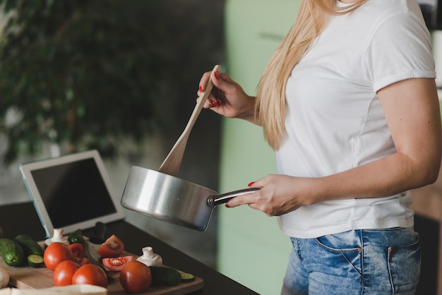 Torso de mujer preparando comida