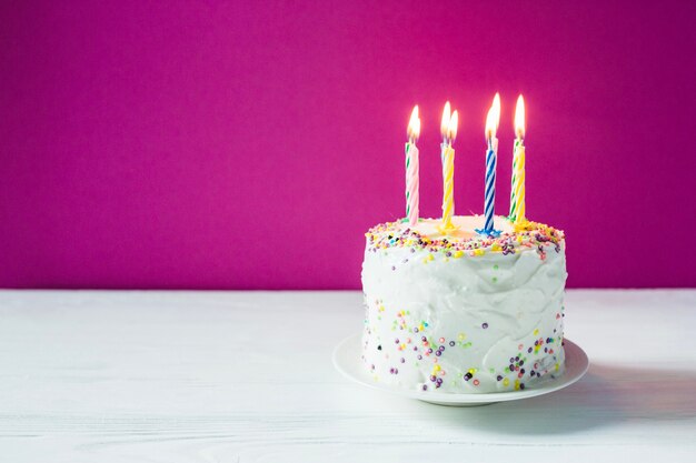 Torta de cumpleaños con velas en la placa