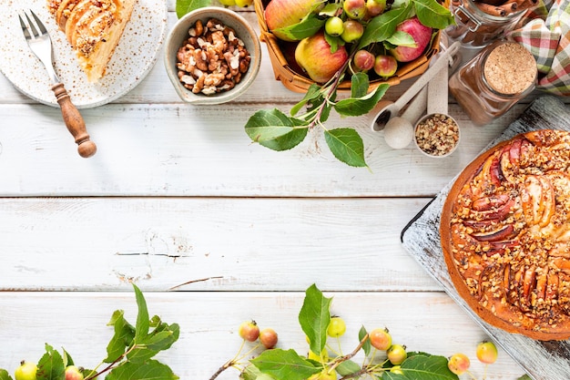 Foto gratuita torta de manzana casera e ingredientes sobre un fondo de madera blanca vista superior espacio de copia