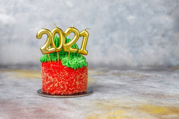 Torta navideña decorada con dulces figuras de árbol de navidad, santa claus y velas.