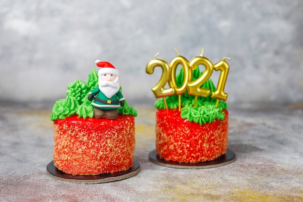 Torta navideña decorada con dulces figuras de árbol de navidad, santa claus y velas.