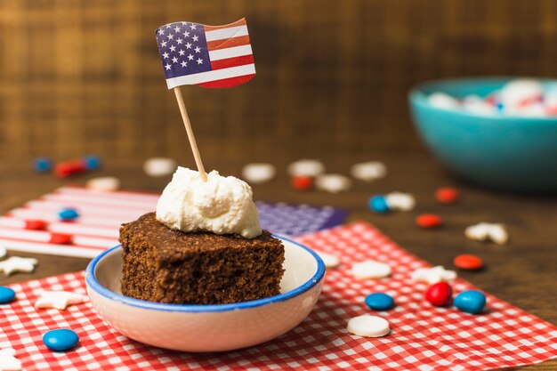 Torta patriótica del 4 de julio con la bandera de Estados Unidos y caramelos en mesa de madera