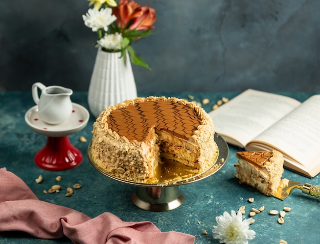 torta de snickers cortada con maní y glaseado de caramelo