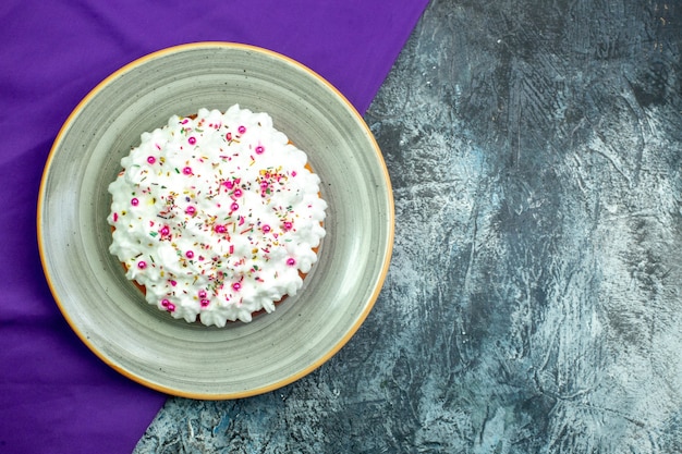 Torta de vista superior con mantón crema púrpura sobre fondo gris