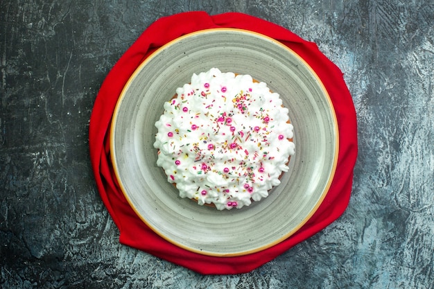 Torta de vista superior con mantón rojo crema sobre fondo gris