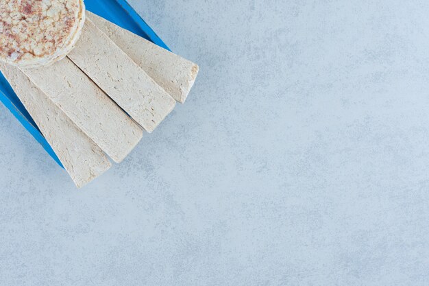 Tortas de arroz inflado sabroso en el plato azul sobre mármol.