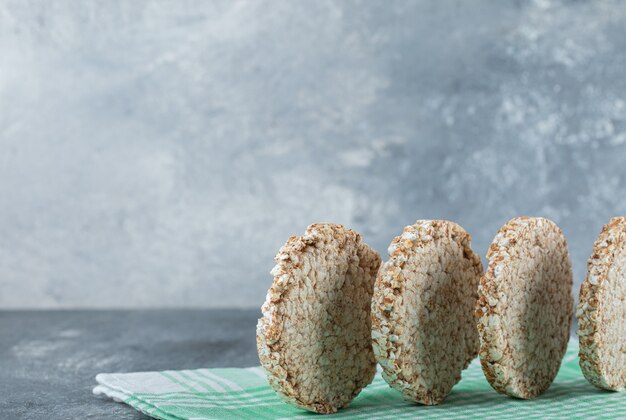 Tortas de arroz redondas dietéticas sobre mantel rayado.