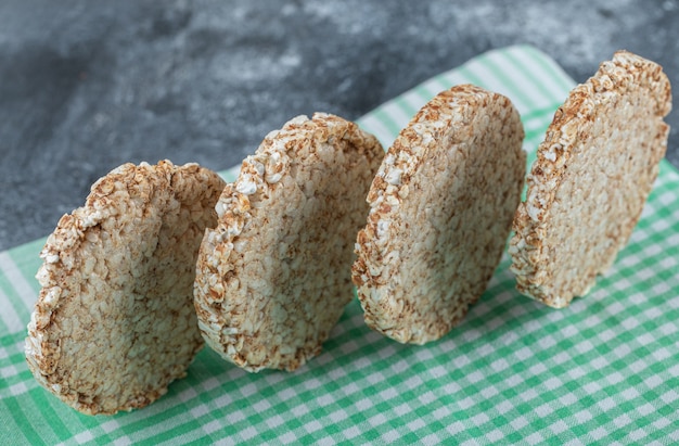 Tortas de arroz redondas dietéticas sobre mantel rayado.