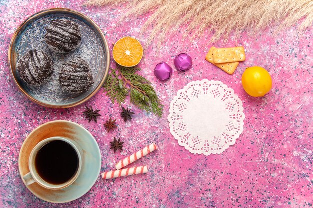 Tortas de chocolate de vista superior con taza de té en rosa