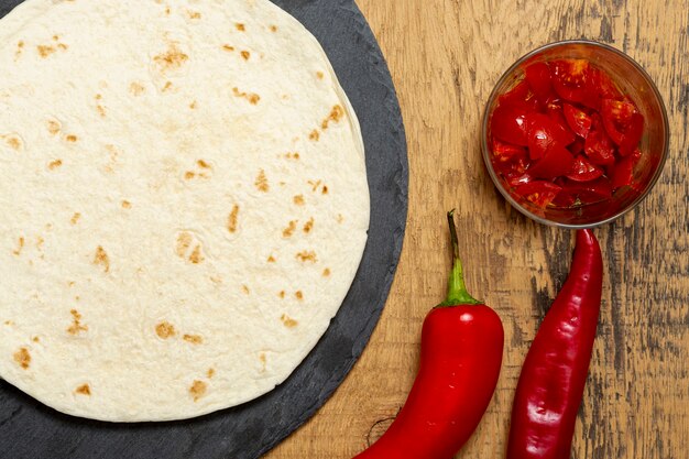 Tortilla cerca de pimiento y rodajas de tomate