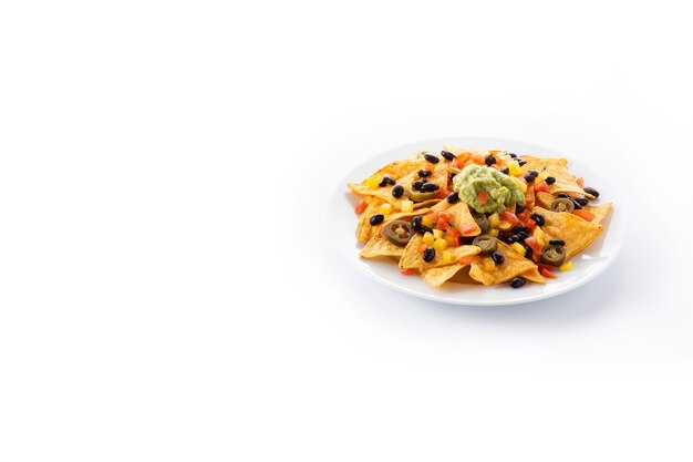 Tortilla chips de nachos mexicanos con frijoles negros, guacamole, tomate y jalapeño aislado sobre fondo blanco.