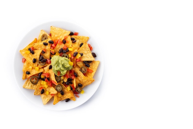 Tortilla chips de nachos mexicanos con frijoles negros, guacamole, tomate y jalapeño aislado sobre fondo blanco.