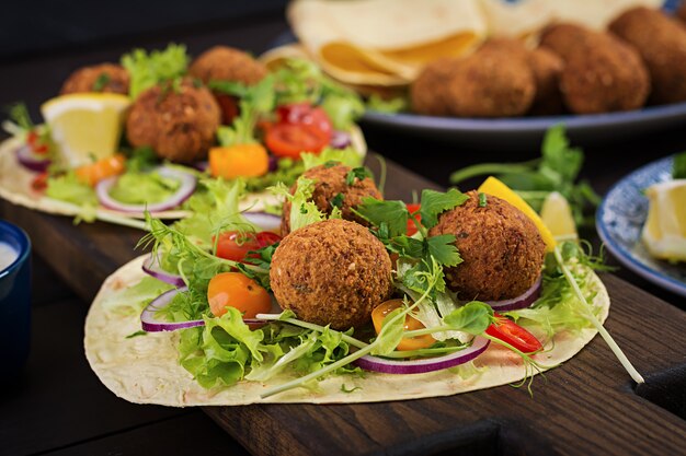 Tortilla envuelta con falafel y ensalada fresca. Tacos veganos. Comida vegetariana saludable.