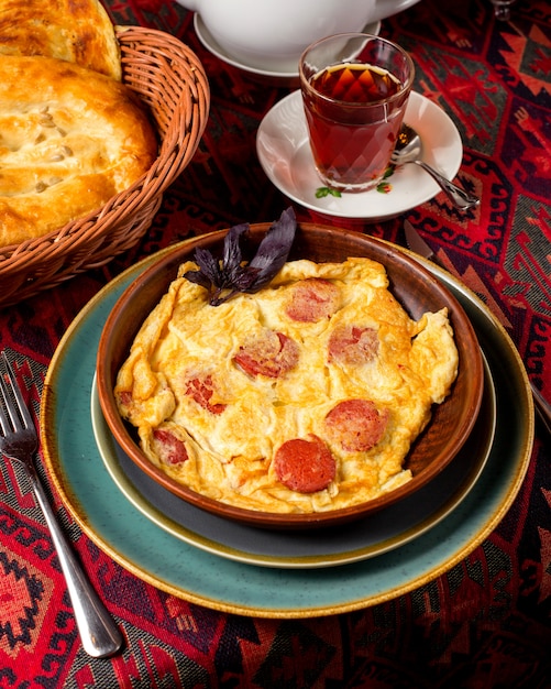 Tortilla de huevos fritos con salchicha sobre la mesa