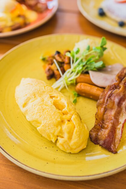 Tortilla con salchicha bacaon jamón con vegetales en plato