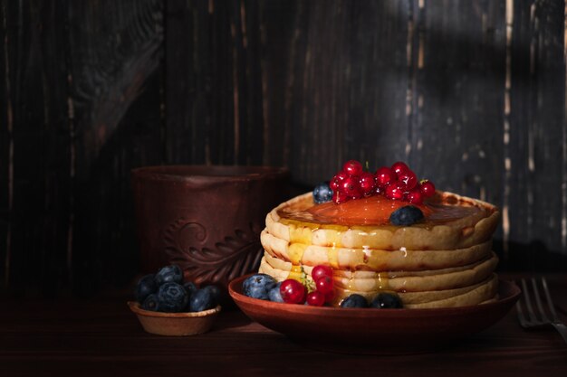 Tortitas dulces con cobertura de arándanos y grosellas. Tortitas caseras con frutos rojos y coco rallado