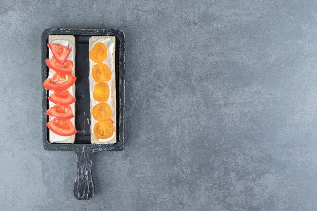 Foto gratuita tostadas crujientes con tomates sobre tabla de madera.