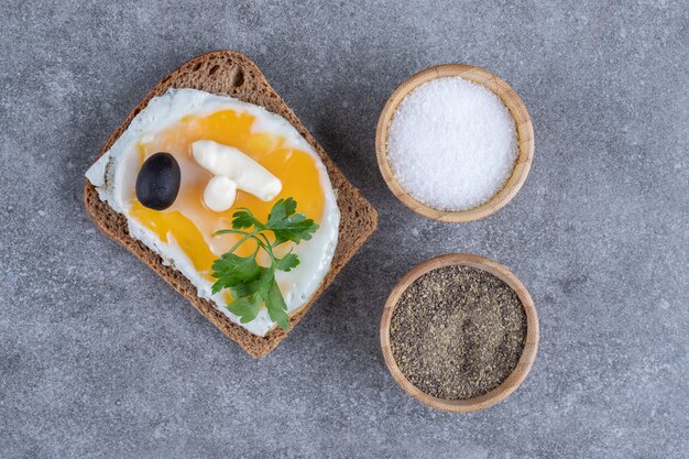 Tostadas con cuencos de madera con sal y pimienta.