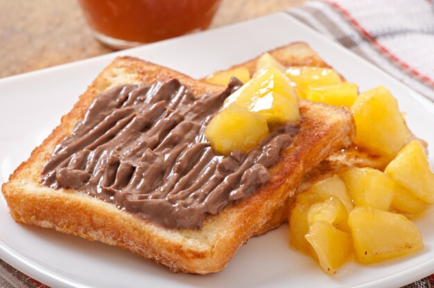 Tostadas francesas con manzanas caramelizadas y crema de chocolate para el desayuno.