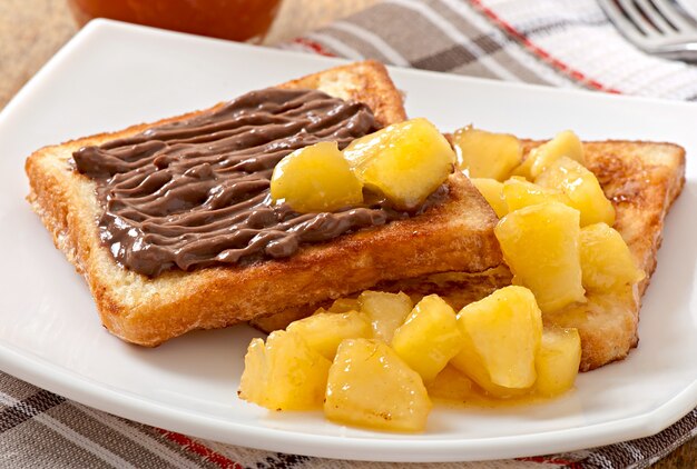 Tostadas francesas con manzanas caramelizadas y crema de chocolate para el desayuno.