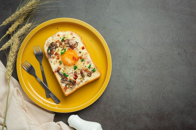 Tostadas con huevo frito y queso crema sobre fondo oscuro