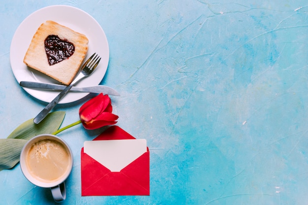 Tostadas con mermelada en forma de corazón con tulipán en mesa