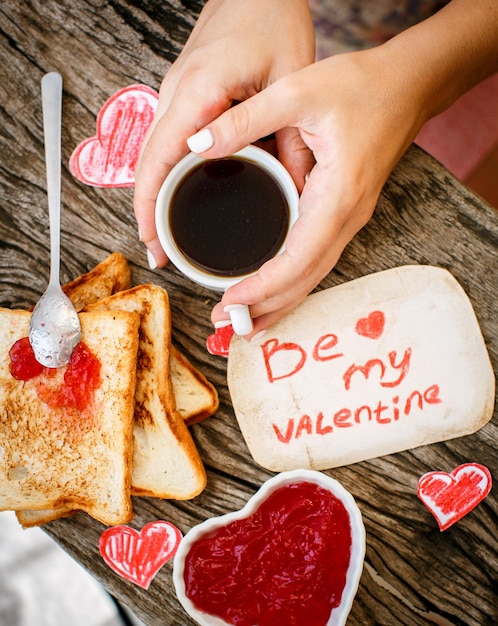 Tostadas con mermelada de fresa tarjeta de mensaje blanca be my valentine con café en las manos día de san valentín