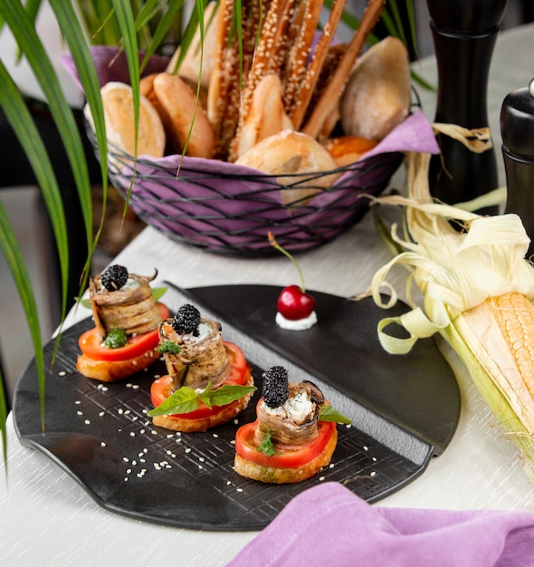 Tostadas con pimientos rojos y rollos de berenjenas.