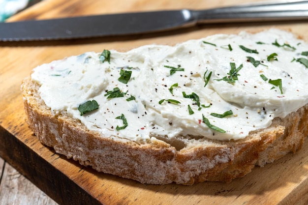 Tostadas de queso crema en tabla de cortar