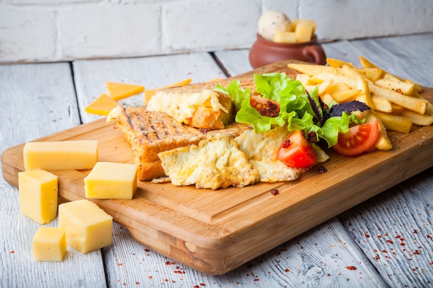 tostadas con queso y tomate y papas fritas en plato