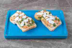 Foto gratuita tostadas con verduras en rodajas en placa azul.