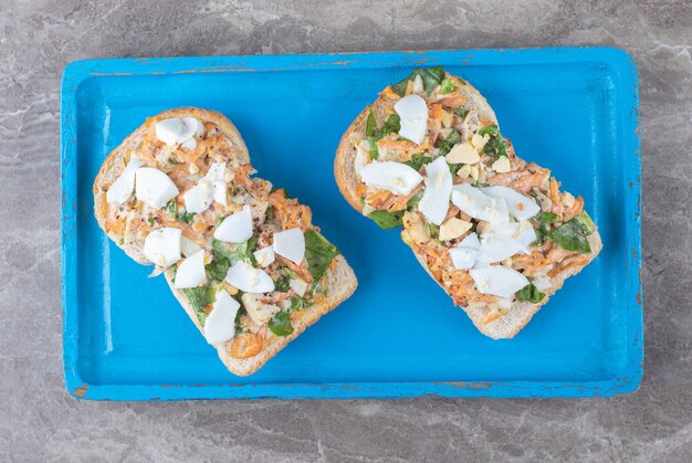 Tostadas con verduras en rodajas en placa azul.