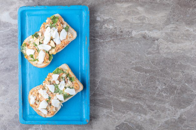 Tostadas con verduras en rodajas en placa azul.