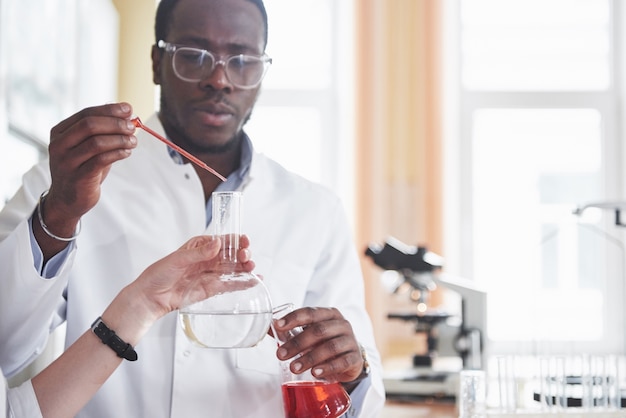 Foto gratuita un trabajador afroamericano trabaja en un laboratorio realizando experimentos.