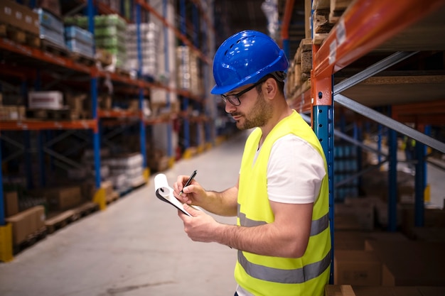 Foto gratuita trabajador de almacén comprobando el inventario en el gran centro de distribución