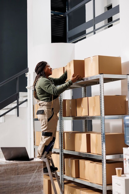 Foto gratuita trabajador de almacén sacando cajas de cartón de la estantería