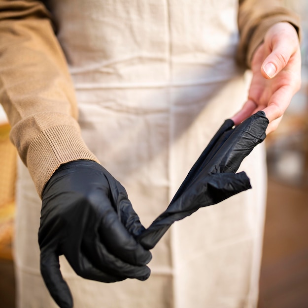 Trabajador de cafetería de primer plano quitándose los guantes