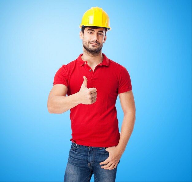 Trabajador con casco amarillo en fondo azul