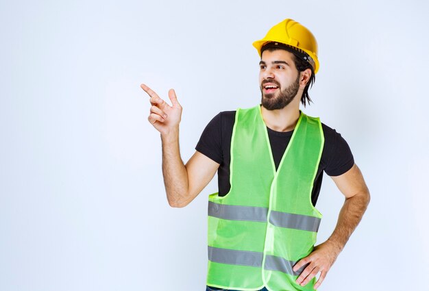 Trabajador en casco amarillo mostrando el lado izquierdo.