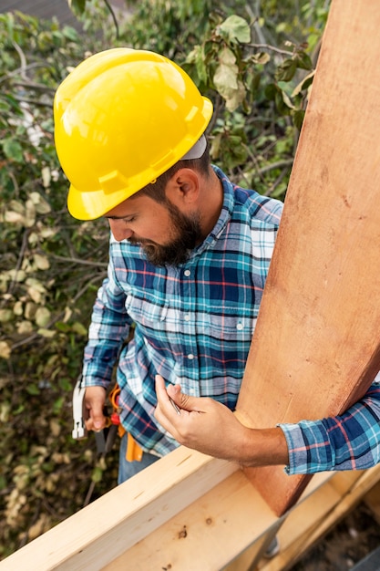 Trabajador con casco de construcción con madera