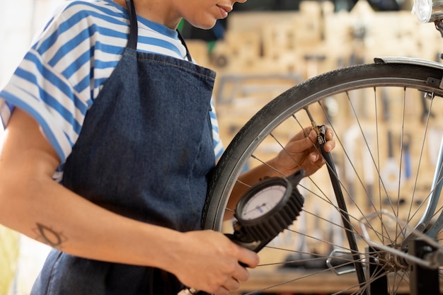 Trabajador de cerca comprobando la rueda de la bicicleta