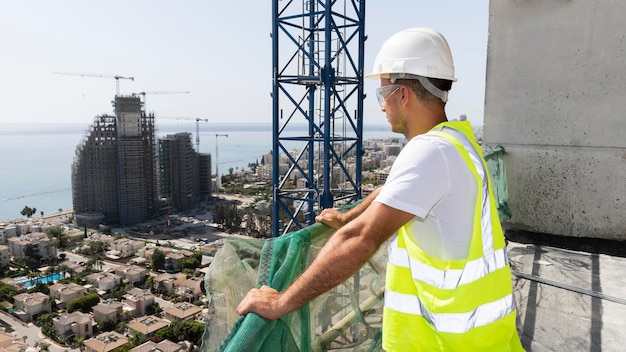 Foto gratuita trabajador de la construcción al aire libre mirando lejos