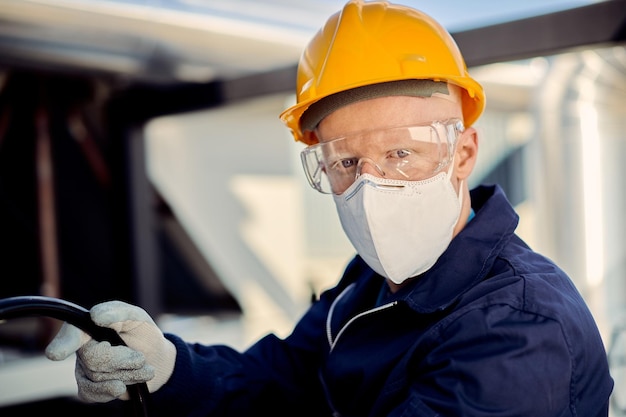 Trabajador de la construcción albino con mascarilla protectora y mirando a la cámara