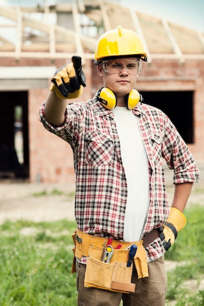 Foto gratuita trabajador de la construcción apuntando a algo