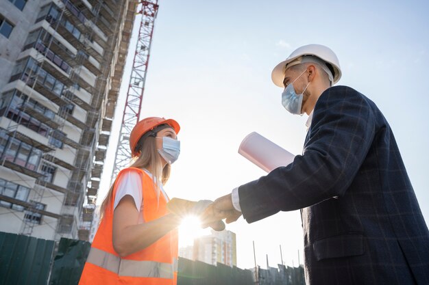 Trabajador de la construcción y la construcción en el sitio con el arquitecto.