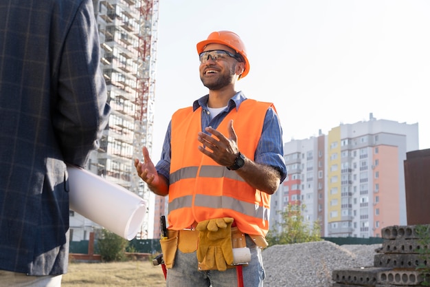 Trabajador de la construcción y la construcción en el sitio con el arquitecto.