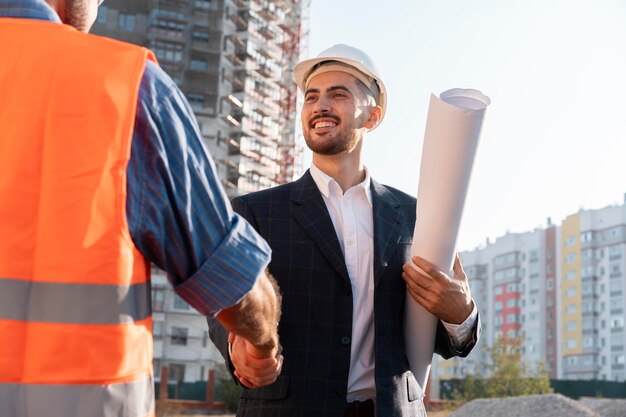 Trabajador de la construcción y la construcción en el sitio con el arquitecto.