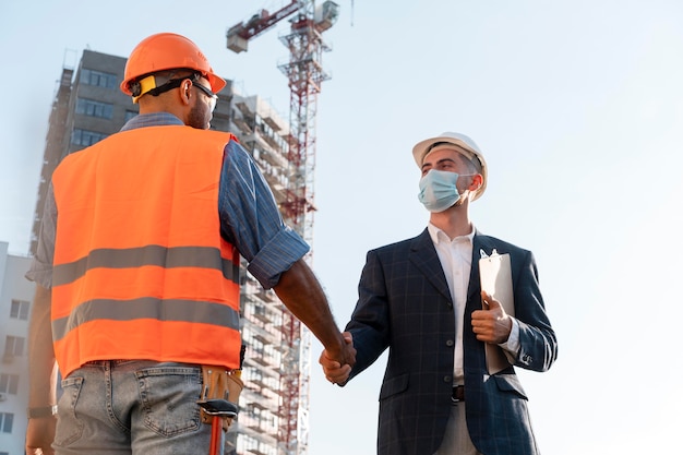 Trabajador de la construcción y la construcción en el sitio con el arquitecto.