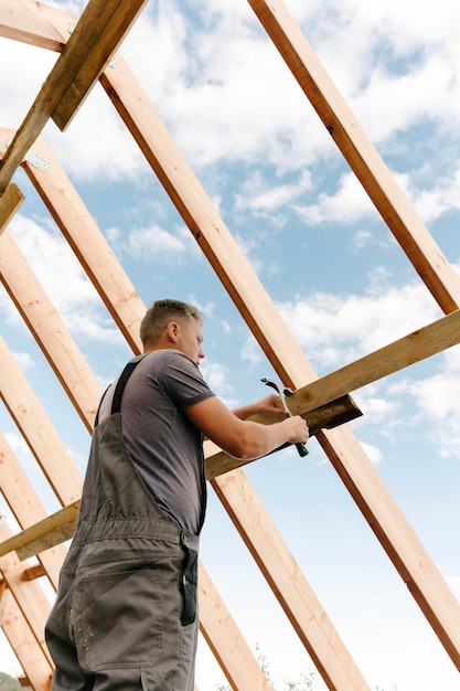 Trabajador de la construcción construyendo el techo de la casa